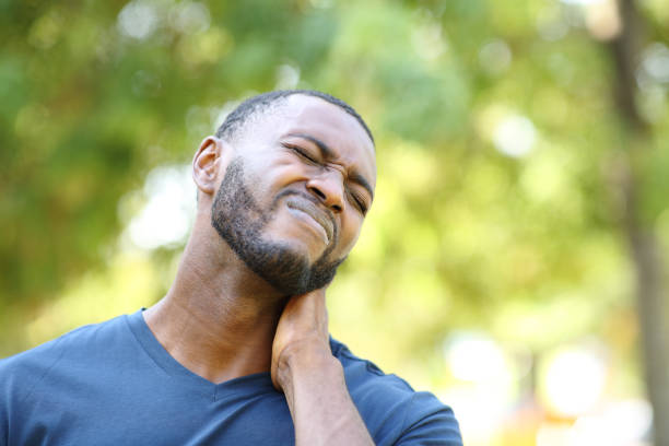 Black man complaining about neck ache Black man complaining about neck ache tetanospasmin stock pictures, royalty-free photos & images