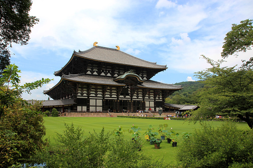 Nara, Japan - August 7, 2015: Todai-ji Temple and its surroundings in Nara seen from the front garden of the temple, in the daytime, with vegetation.