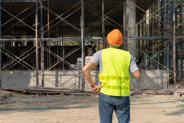 Rear view of engineer or contractor standing at a building site. Young businessman construction site engineer. stock photo
