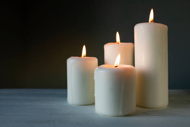 istock Large burning candles on a dark background. Side view, place for text. 1344784336