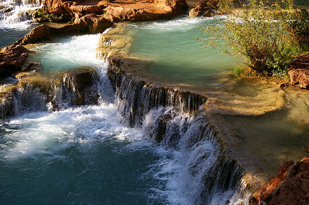 Water falls down nature-made tiers at Havasu Falls, Arizona.