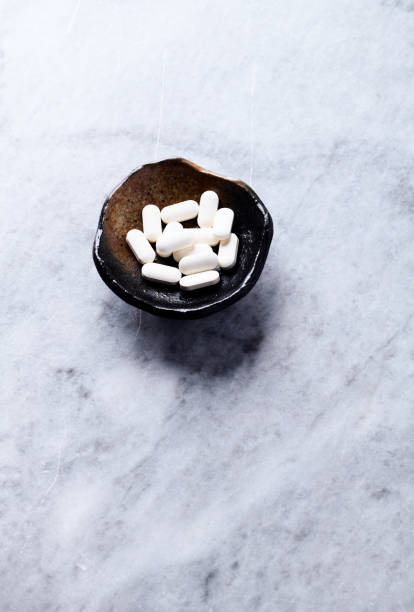 istock Korean Ginseng tablets. Concept for a healthy dietary supplementation. Bright stone background. Soft focus. Copy space. 1344787366