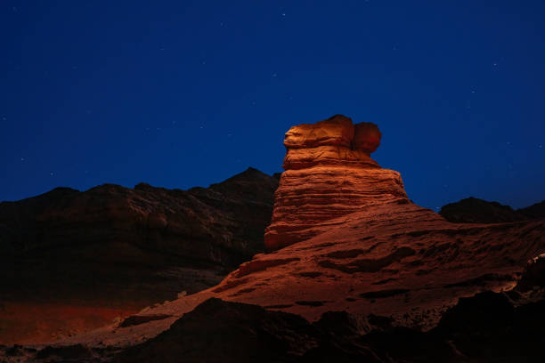 istock Sandstone rock is illuminated by a flashlight in Herman Cav Canyon at night. South Gobi, Mongolia. Herman Tsav, Martian landscape and the site of many paleontological finds. Cemetery of dinosaurs 1344787921