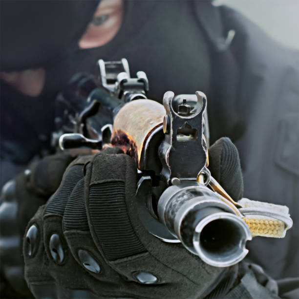 istock Machine gun in the hands of a killer close-up. Blurred image without focus. 1344790506
