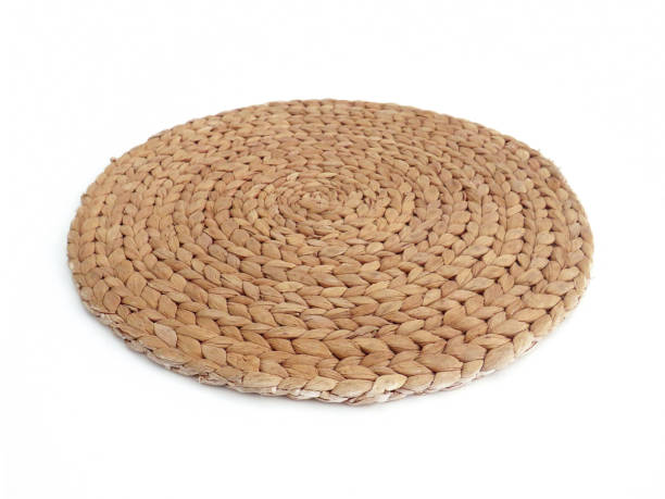 istock View of handmade round beige wicker tablecloth surface isolated on white background; Close-up of single oval water mat of water hyacinth fabric. Rustic appearance. Environmentally friendly. 1344791936