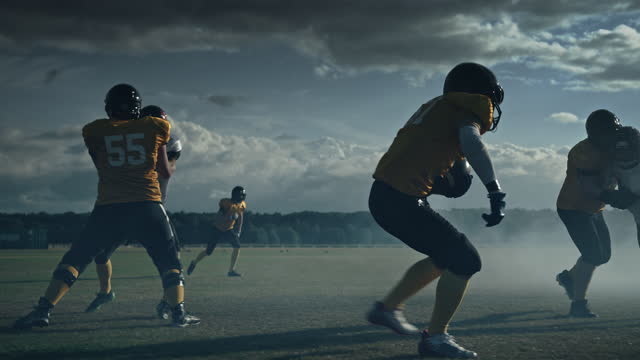 American Football Field Two Teams Compete: Players Pass and Run to Score Touchdown Points. Professional Athletes Compete for the Ball, Tackle, Fight for Championship Victory. Cinematic Slow Motion