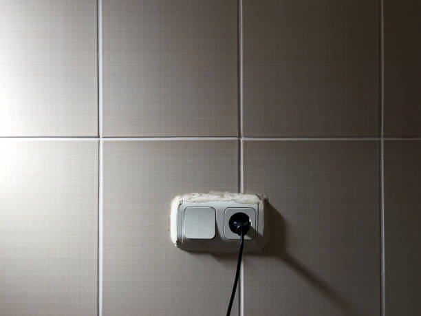 istock Electrical outlet and light switch with electric plug on the wall 1344795111