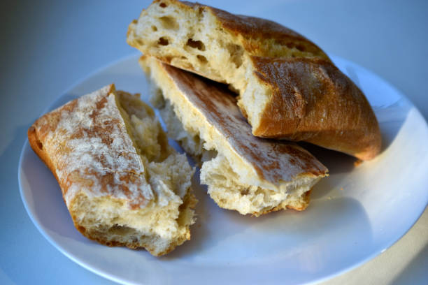 istock Fresh ruddy bread in chunks on a white plate 1344795481