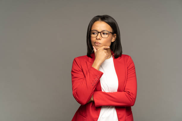 empresária afro-americana toma decisão confusa pensamento duvidoso ponderando sobre solução de problema - thinking women businesswoman business person - fotografias e filmes do acervo