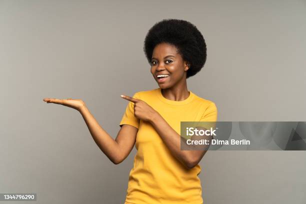 Happy Excited Female Point Finger To Open Palm With Empty Space For Product Placement Happy Smiling Stock Photo - Download Image Now