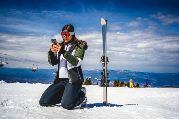istock Female skier using mobile phone 1344797497