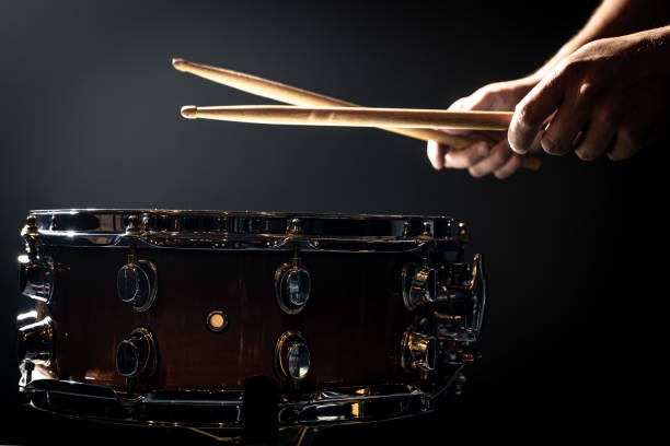istock Snare drum and drummer's hands hitting drumsticks against a dark background. 1344800164