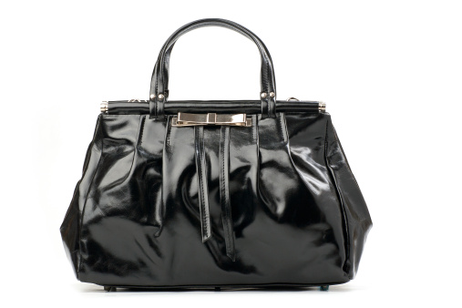 Black female handbag over white background