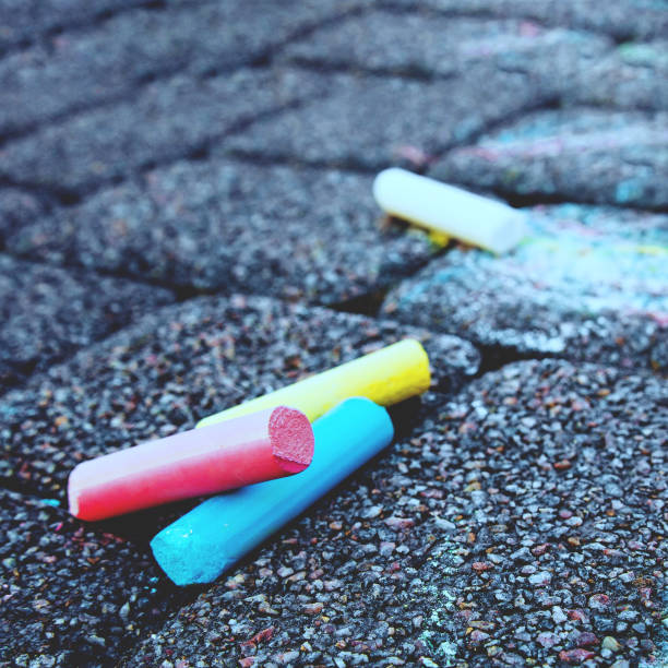 istock Blurred image Colorful pastel sidewalk chalk on dark asphalt background. 1344800751
