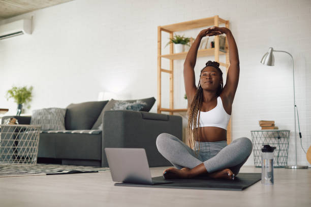 istock Young black athletic woman doing Yoga relaxation exercise during home workout. 1344803564