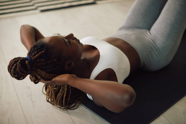 istock African American athletic woman exercising sit-ups while working out at home. 1344803574