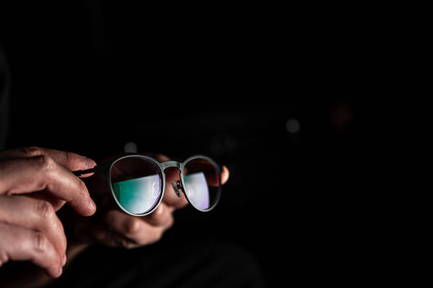 istock Glasses for working at the computer in male hands on a black background. 1344803665