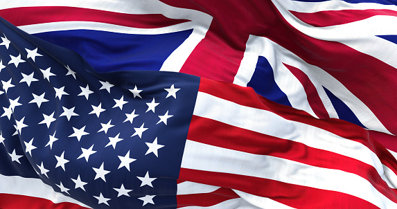 The flags of the United States and the United Kingdom waving in the wind. International relations and diplomacy.