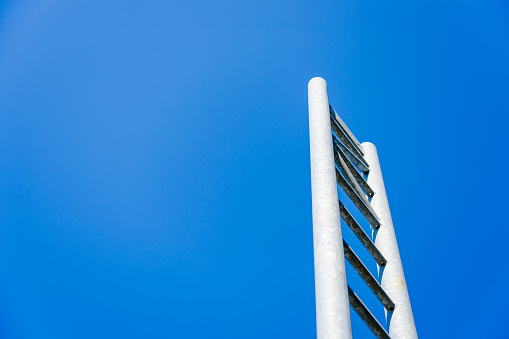 Metal ladder against blue sky. With copy space. Shot with a 35-mm full-frame 61MP Sony A7R IV.