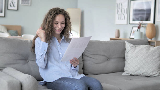 istock Excited Curly Hair Woman Cheering while Reading New Contract 1344811841
