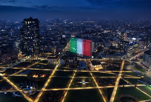 Milan Lombardy Italy 12.14.2020 Night aerial view of the park in the Porta Nuova district with one of the buildings illuminated with the colors of the Italian flag.