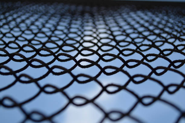 Rusty grid fence on the background of the sky