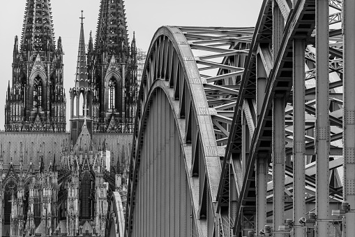 Nice black and white picture of the great Dom of Koln in Germany. In this picture you see the industrial railway bridge near this big cathedral at the banks of river Rhine.