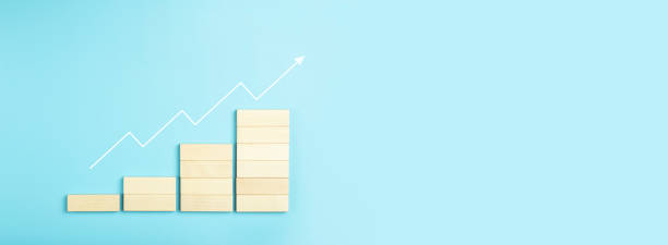 istock Business growth, development plan concept and business analytics background. Wooden steps of blocks on a blue background as financial and career growth, increase in monetary income and economic development. 1344814403