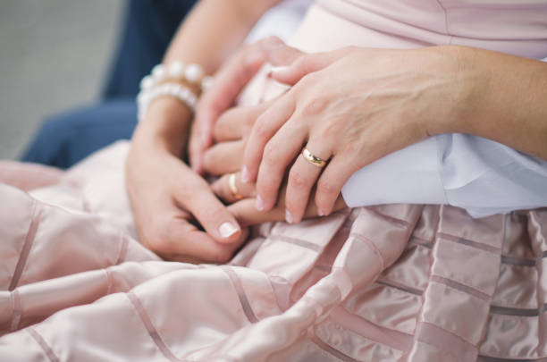 istock A couple sit on a bench. Her hands hold his hand 1344814545