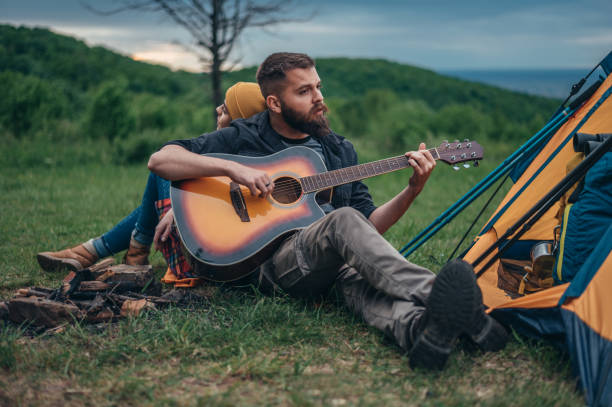 istock Couple of campers playing a guitar while having a romantic date 1344814888