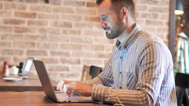 istock Beard Casual Man working on Laptop in Loft Place 1344815975