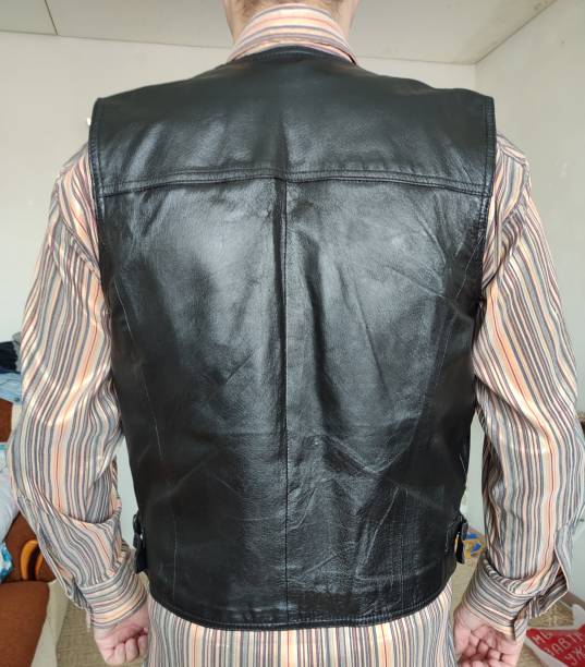 istock Man in a leather vest at home, back view 1344816403