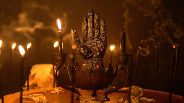 Palmistry and table statue of the black hand at fortune teller table. Mystic palm reading and magical black candles on candle holder. Occult knowledge and occultism. Spiritual mood. stock photo