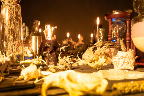 istock Witchcraft still life with burning candles selective focus on skull. Esoteric gothic and occult witch table for Halloween. Magic objects and ritual arrangement. Shallow depth of field. 1344817815