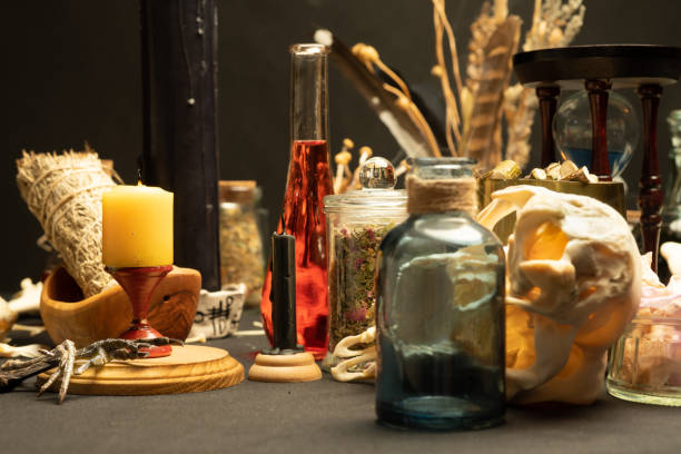 istock Witchcraft still life with black burning candles selective focus. Esoteric gothic and occult witch table for Halloween. Various magic objects and ritual arrangement. Gothic Halloween. 1344817935