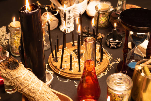 istock Witchcraft still life with black burning candles selective focus. Esoteric gothic and occult witch table for Halloween. Various magic objects and ritual arrangement. Gothic Halloween. 1344818008