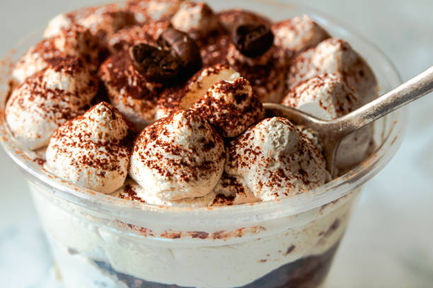 Served Italian dessert Tiramisu, cream, cocoa powder in a plastic take away cup.Healthy food and diet concept, restaurant dish delivery stock photo