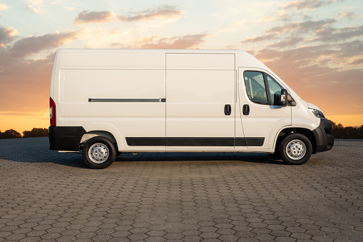 side view with copyspace, of White delivery van at sunset ready for branding