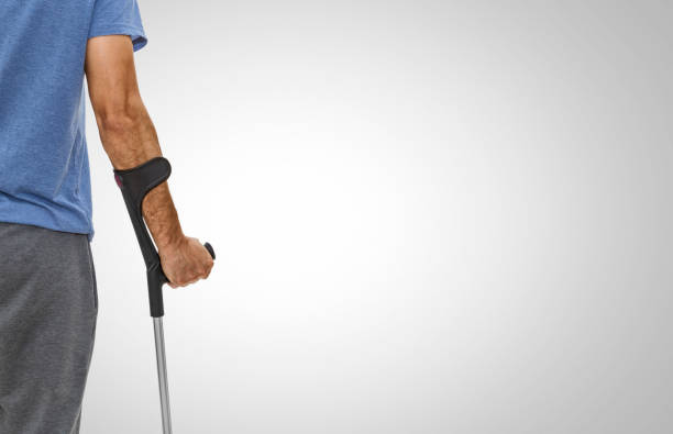 il braccio di un uomo tiene una stampella - men crutch isolated support foto e immagini stock