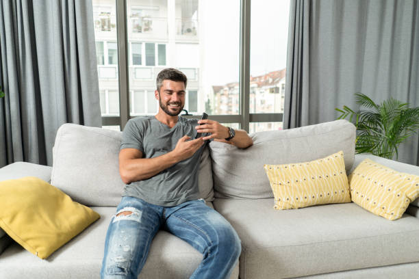 istock Young man relaxing at home and making a phone call. 1344825672
