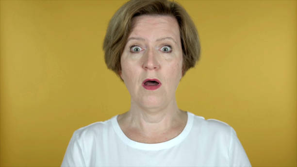 istock Surprised Old Woman in Shock Isolated on Yellow Background 1344826620