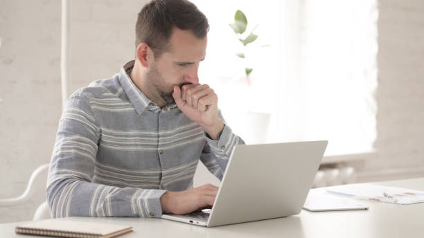 istock Ill Adult Man Coughing at Work 1344826989