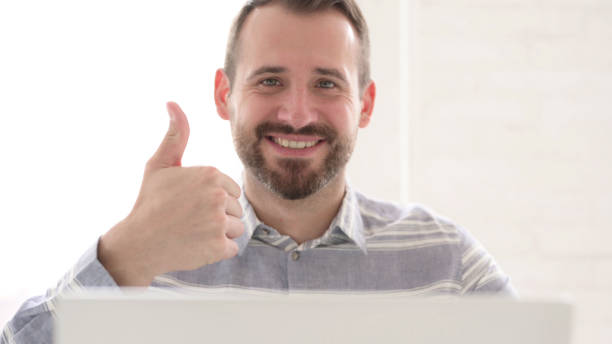 istock Thumbs Up by Casual Man Looking at Camera 1344826997