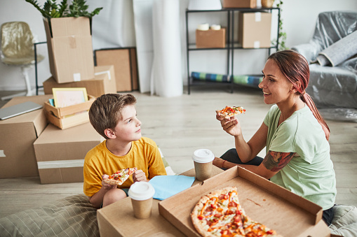 Madre e hijo comiendo pizza en un nuevo hogar photo