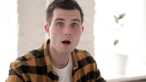 istock Shocked Casual Young Man Looking at Camera 1344828091