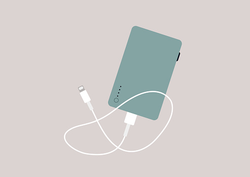A power bank device with a mobile phone charging cable isolated on a plain background