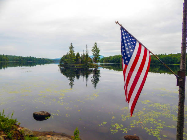 istock American flag hoisted on a tree with a large lake in the background 1344831413