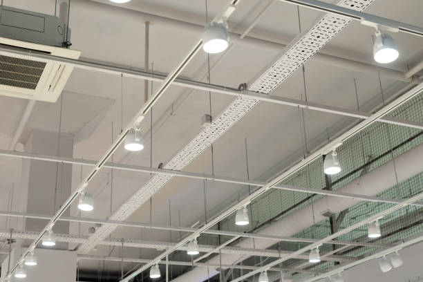 現代の倉庫、ショッピングセンターの建物、オフィスや他の商業用不動産オブジェクトに明るいライトと天井。天井の下のレールの指向性 led ライト - イルミネーション ストックフォトと画像