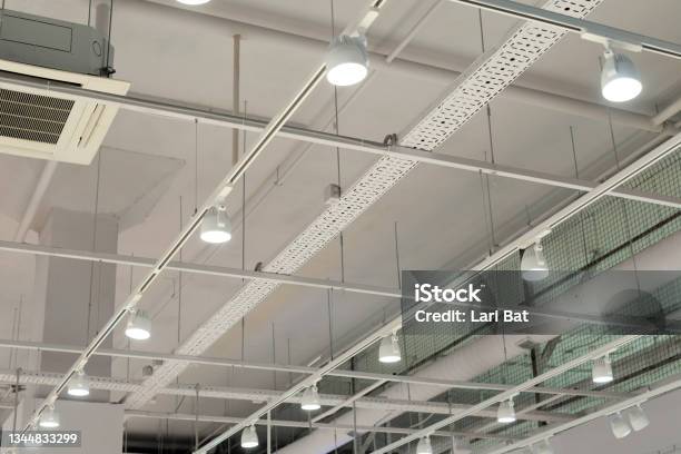 Ceiling With Bright Lights In A Modern Warehouse Shopping Center Building Office Or Other Commercial Real Estate Object Directional Led Lights On Rails Under The Ceiling Stock Photo - Download Image Now