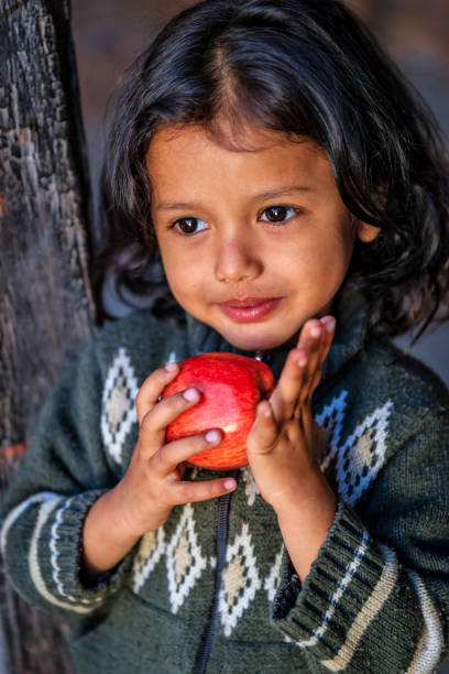 retrato da menina nepalês feliz comendo uma maçã, bhaktapur, nepal - indian culture child little girls indigenous culture - fotografias e filmes do acervo